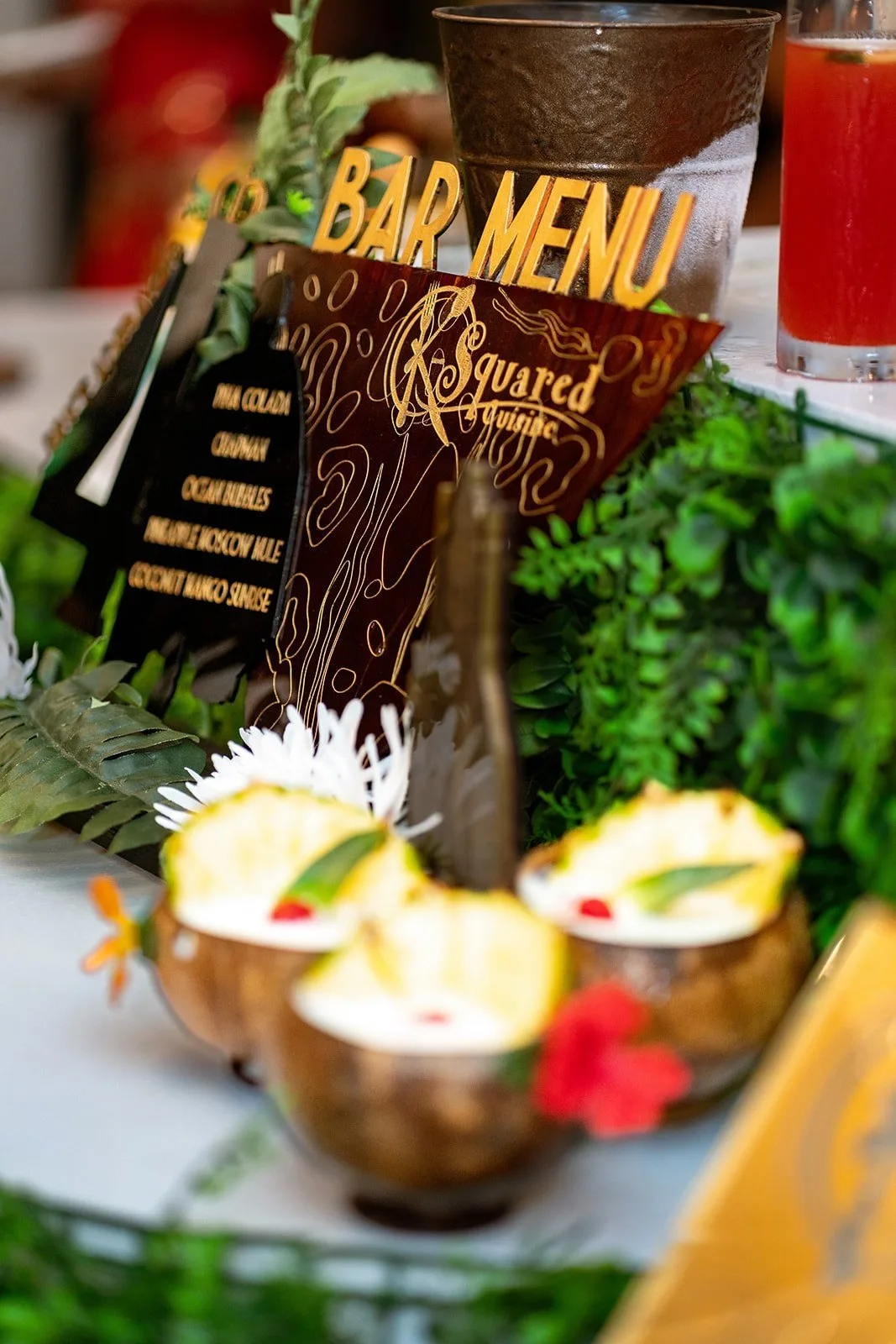 Bar menu sign beside piña coladas in coconut shells