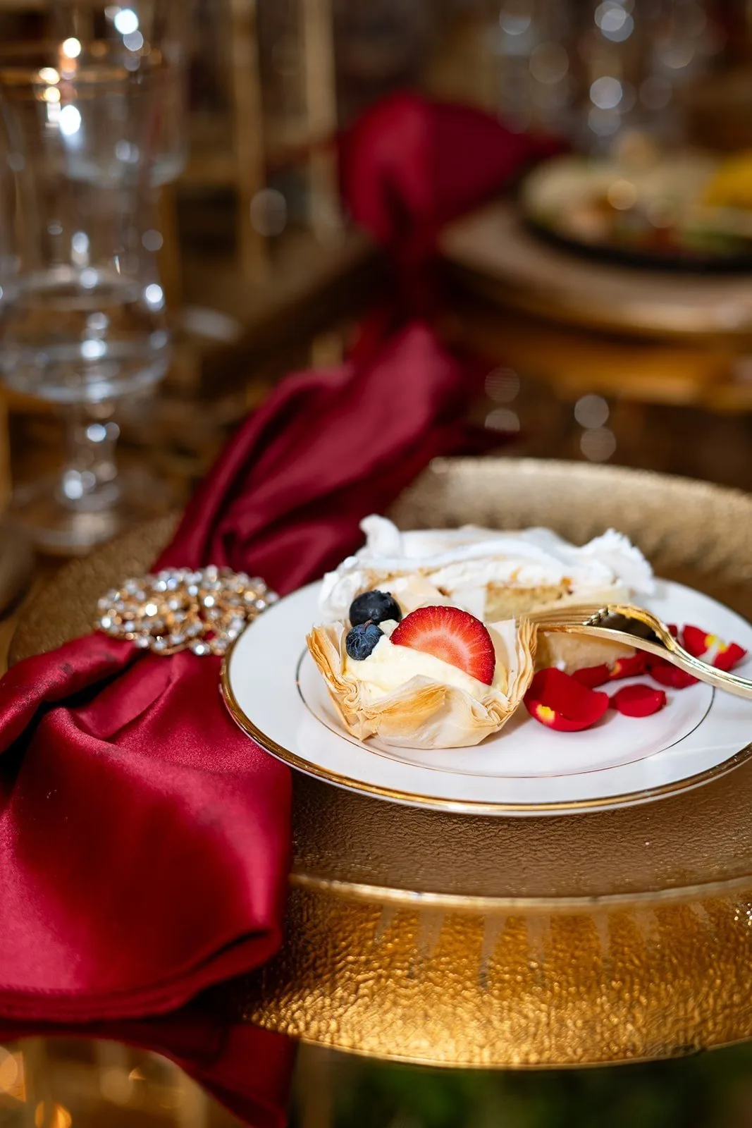 Berry cream pastry with strawberry and blueberry on a gold-rimmed plate