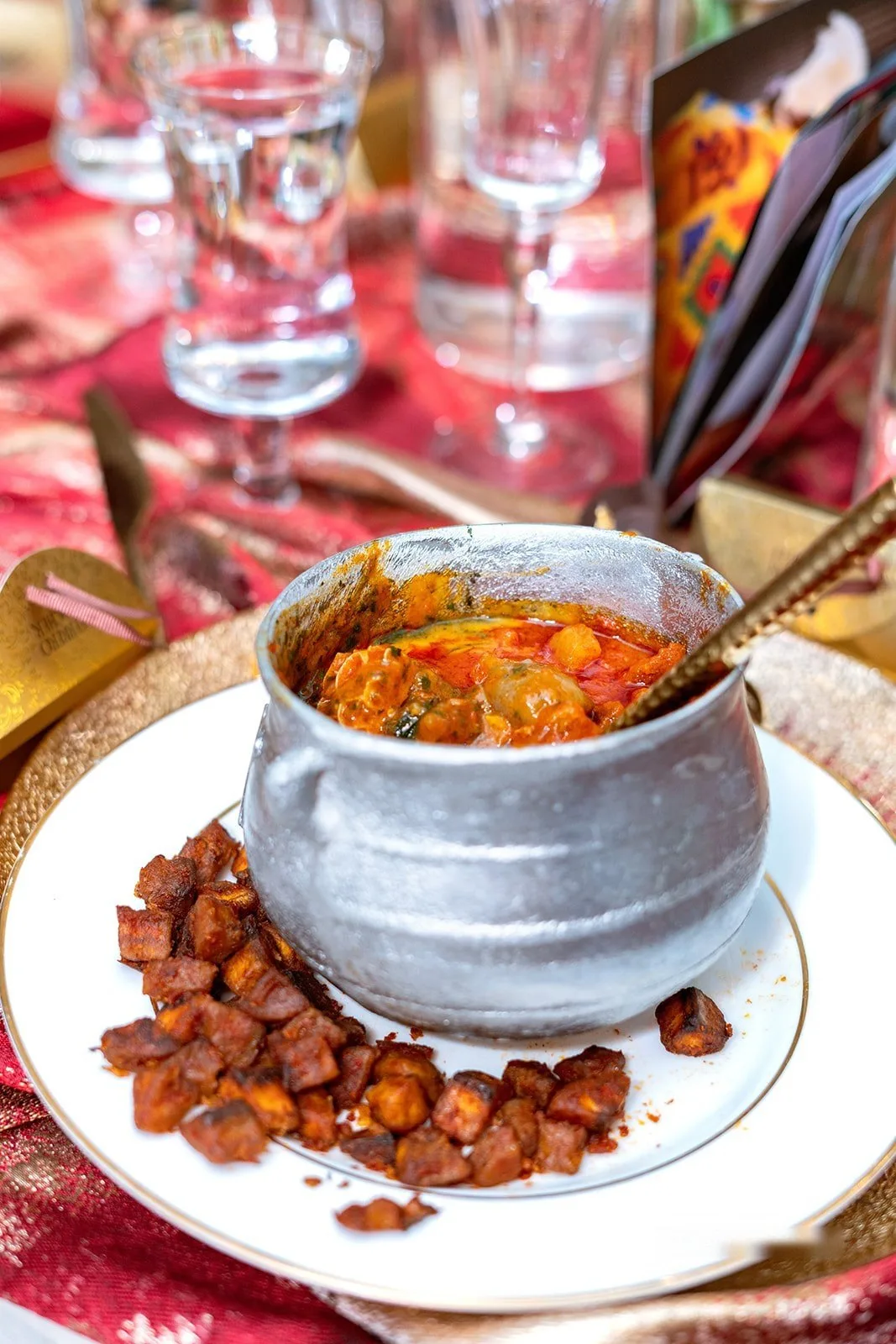 Pepper soup served in a silver pot at a reception table